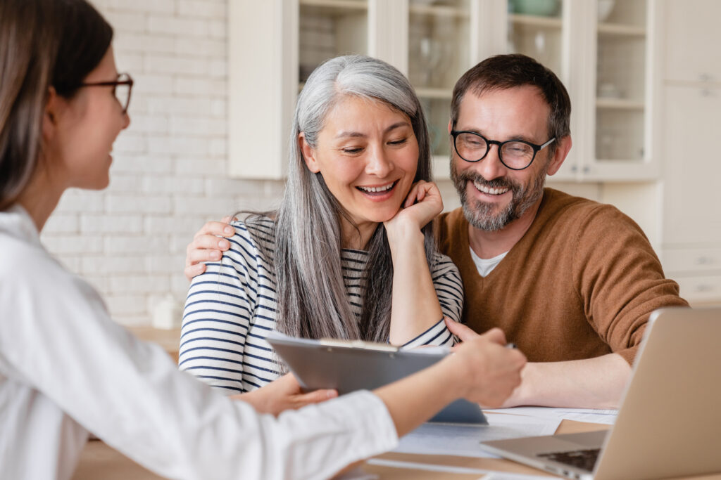 A broker explaining home loan documents to a couple before they sign