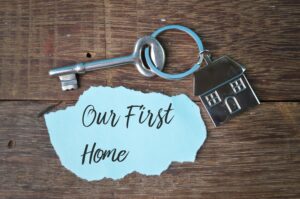 House key with an 'Our First Home' note, symbolising first home ownership